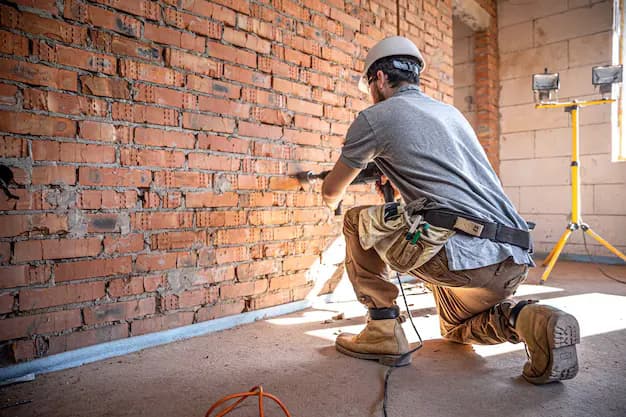 Albañil trabajando en una pared de ladrillo en una obra