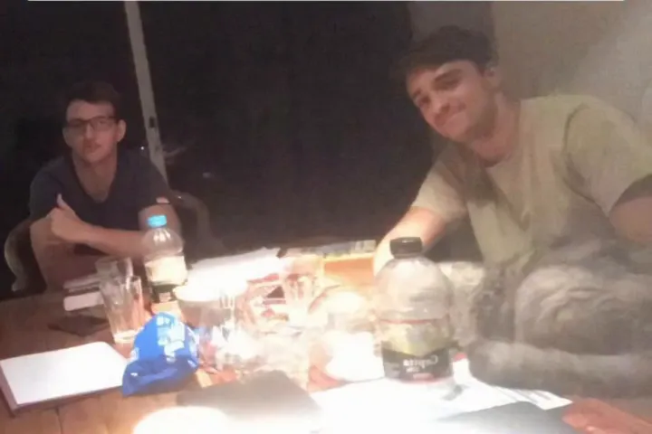 Dos jóvenes reunidos de noche alrededor de una mesa, en los comienzos del proyecto