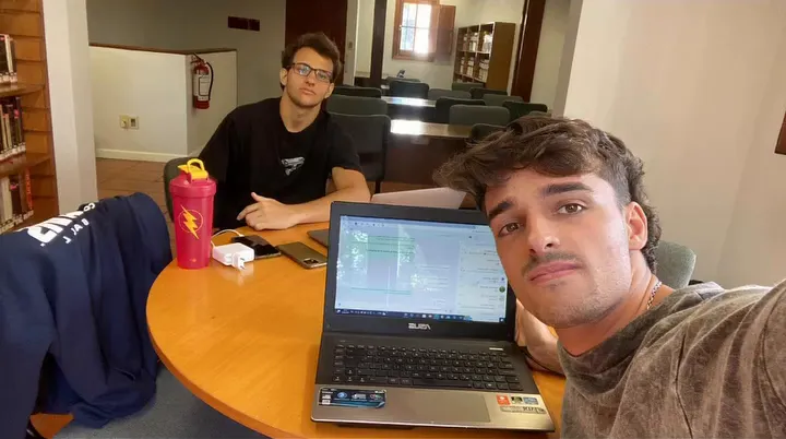 Dos jóvenes con una notebook en una mesa redonda