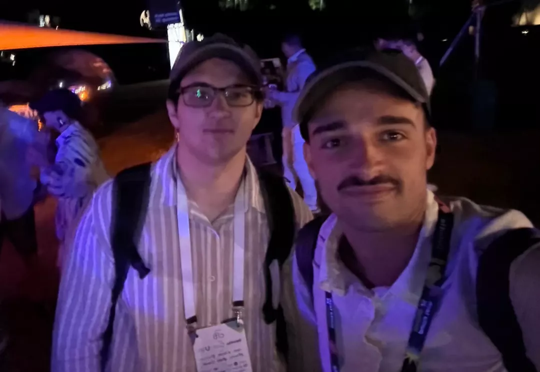 Los fundadores de ArreglaTodo en un evento de emprendimiento, de noche, con credenciales