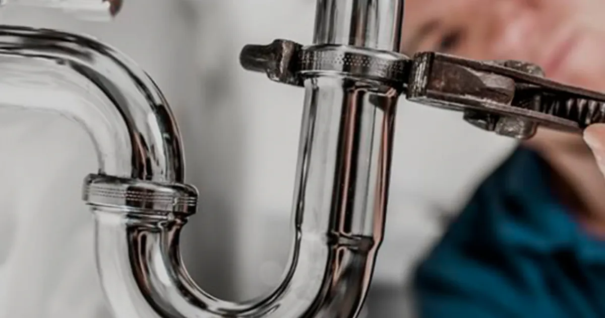 Sanitario ajustando con una llave el sifón de una pileta